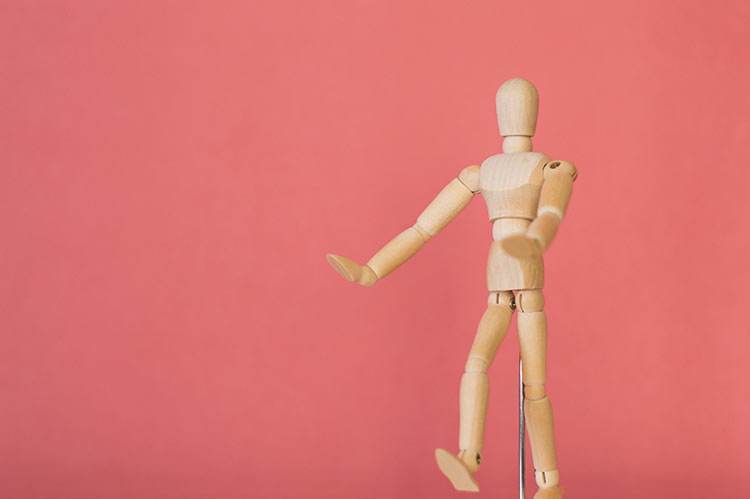 粉红色背景的木制机器人木偶